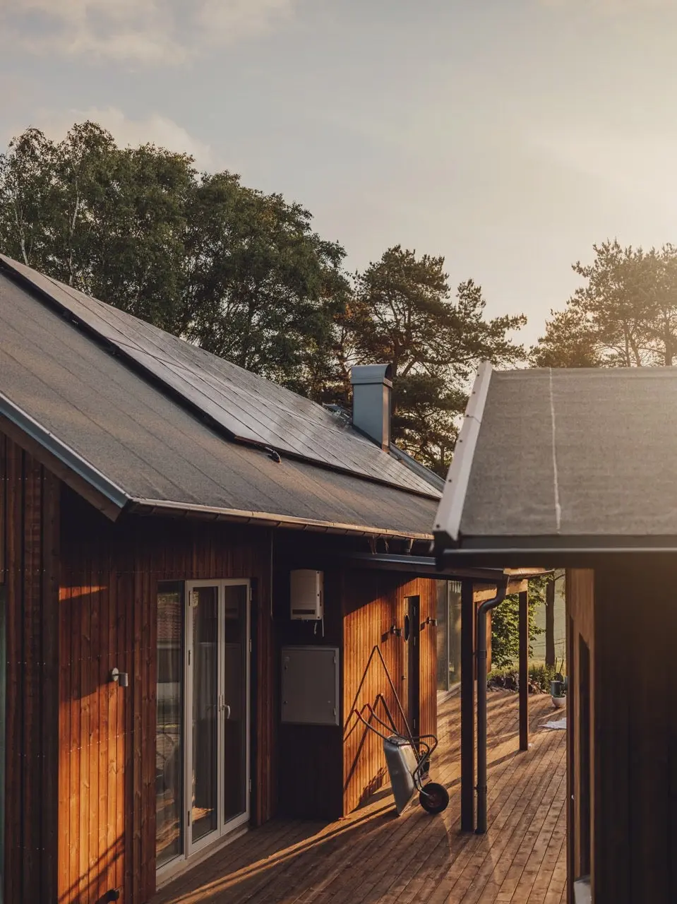 Blockhaus umzingelt von Bäumen mit PV-Anlage (Miet-Solaranlagen - wie geht das?).