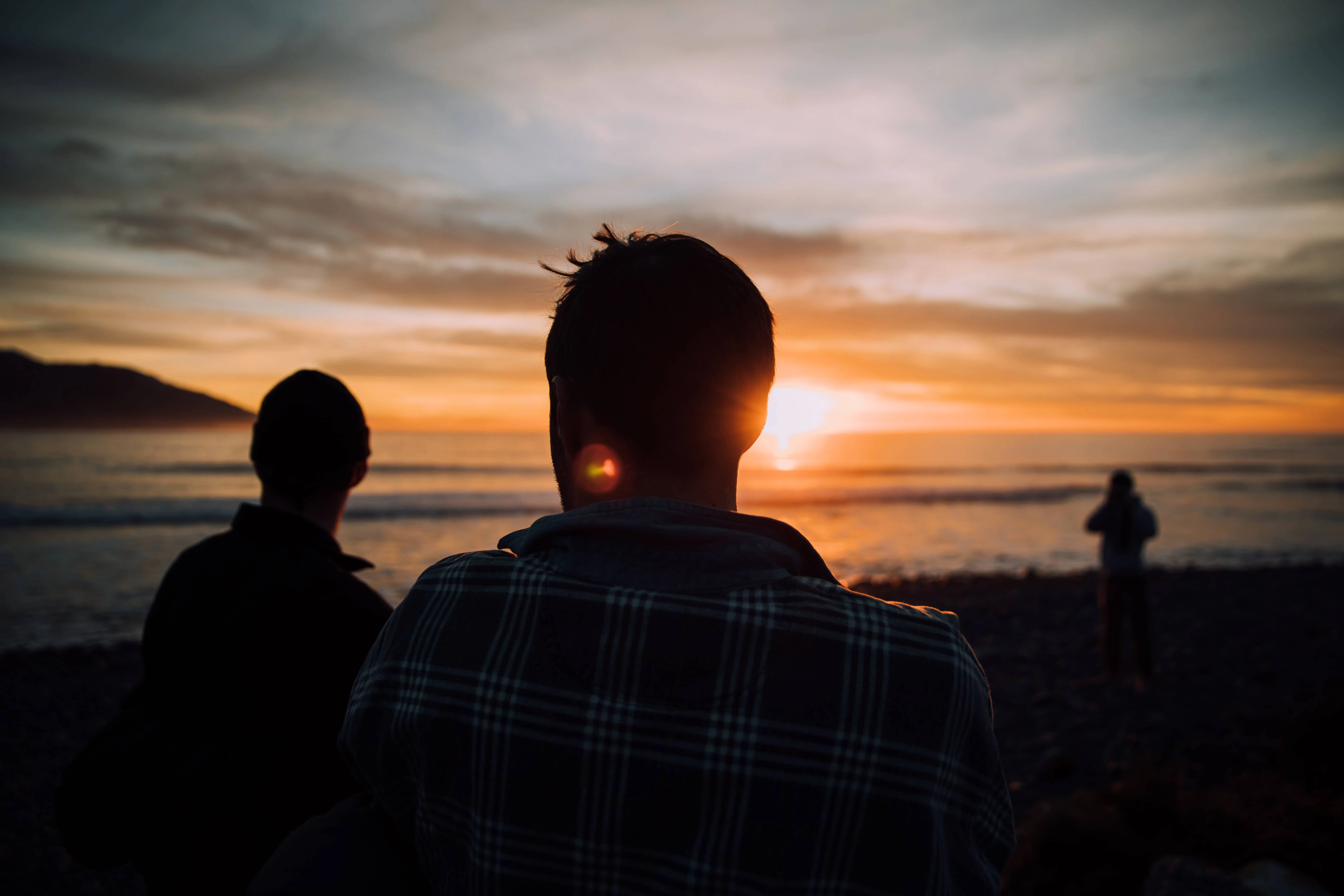 Eine Gruppe von Menschen am Meer bei Sonnenuntergang. (Über Svea Solar)