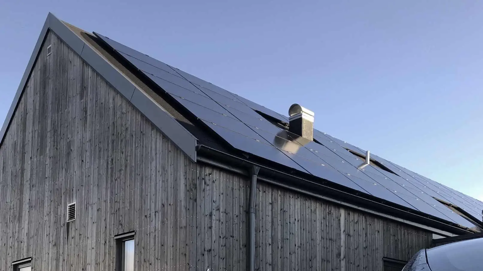Ett hus med naturfasad och solceller på taket