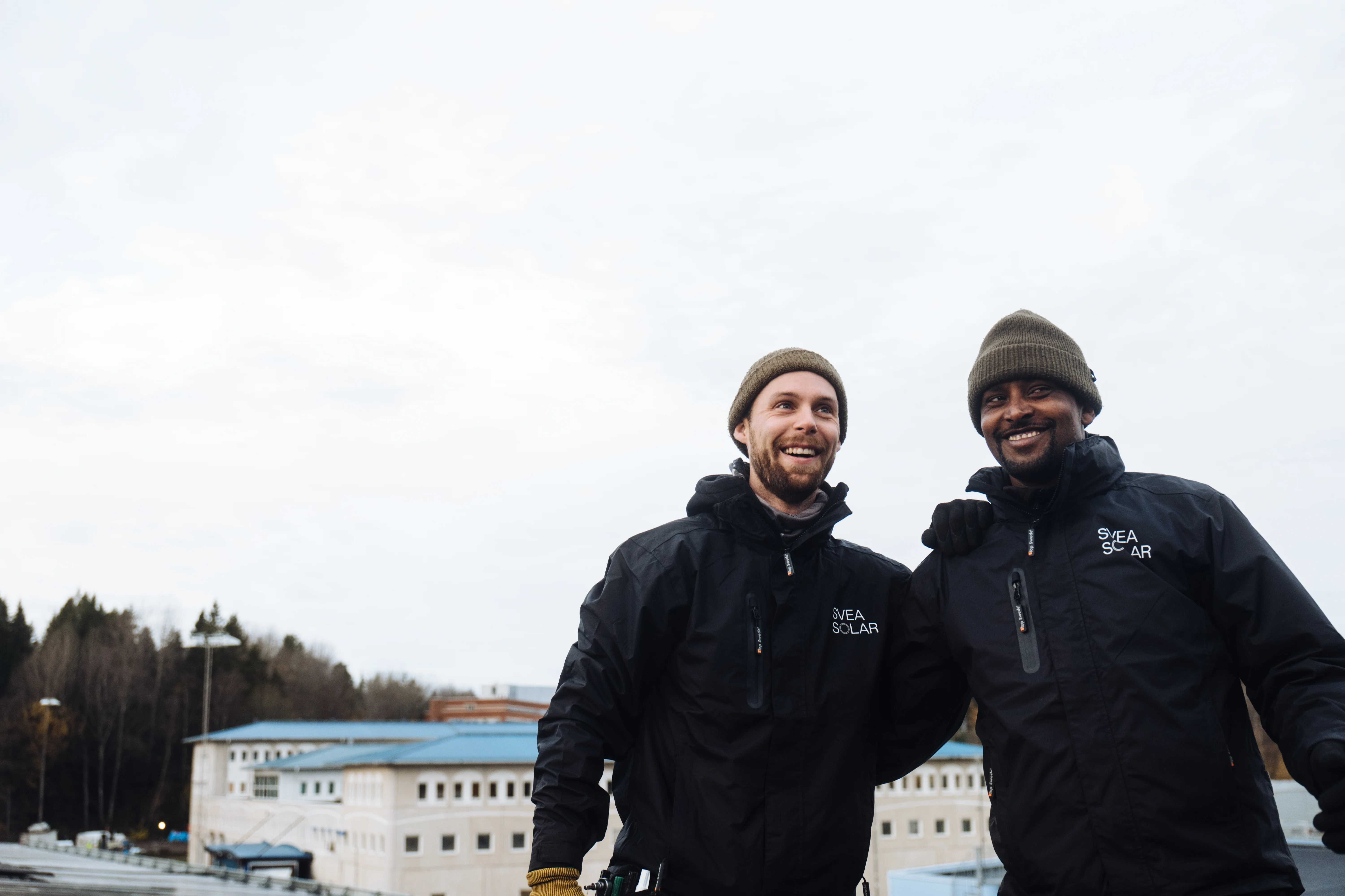 Zwei Svea Solar Mitarbeitende auf Dach mit Photovoltaikanlage – Installation und Service für Solaranlagen