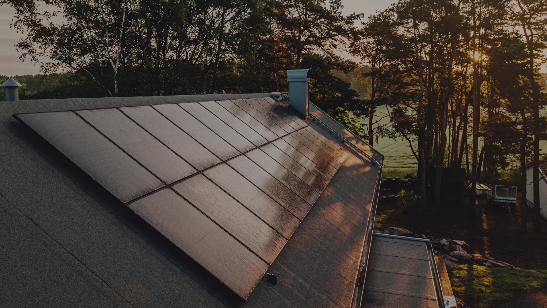 Holzhaus mit Solarmodulen auf dem Dach leicht verdunkelt.