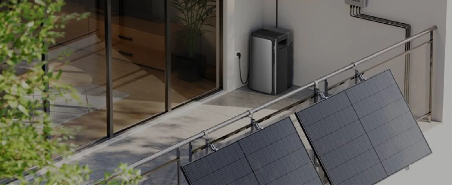 Balkon mit zwei Solarpanelen an dem Geländer und einem Speicher in der Ecke