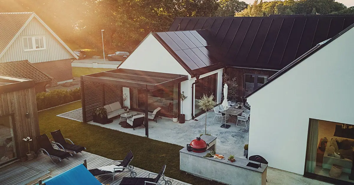 Einfamilienhaus mit einer Photovoltaikanlage auf dem Dach. Vogelperspektive aus dem Garten.